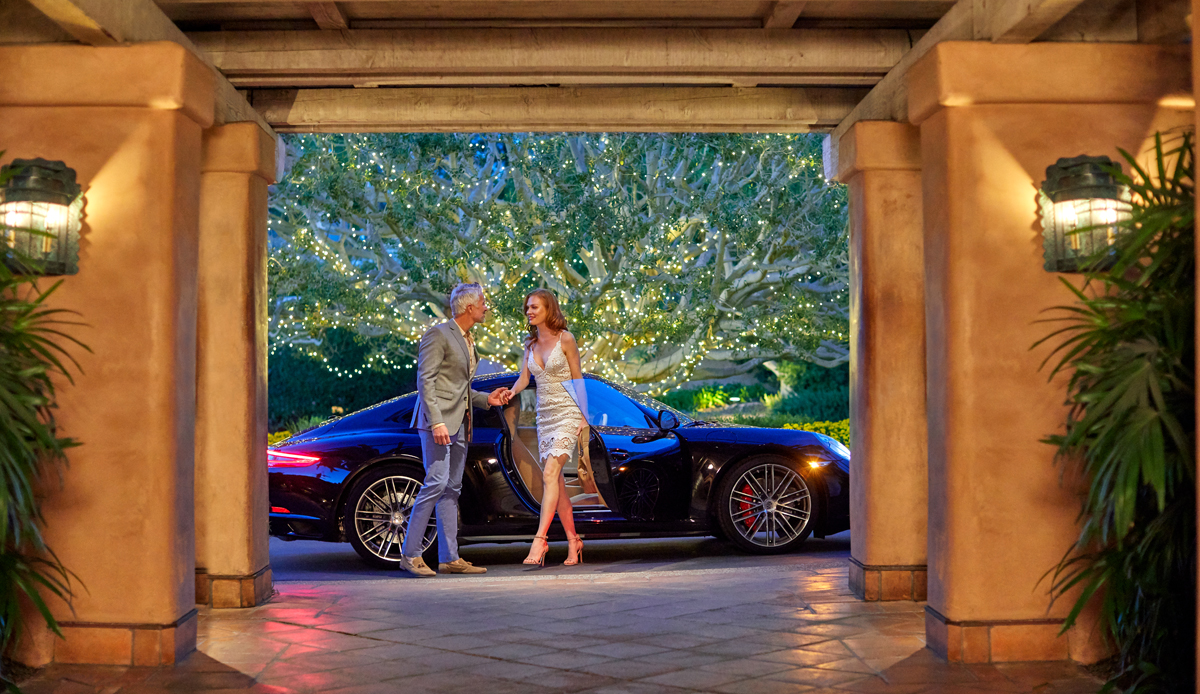 Couple arriving at entrance to North San Diego 5 star resort, Rancho Valencia, in Porsche