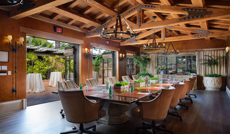 Boardroom with bucket chairs, wood ceilings, and patio in background
