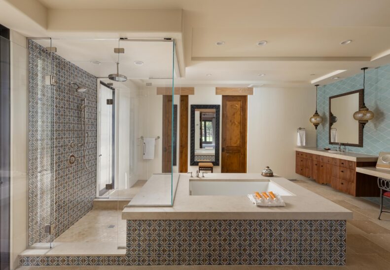 An elegant shower and tub with intricate tile and natural stone in Casa Valencia, Rancho Valencia's private residence.