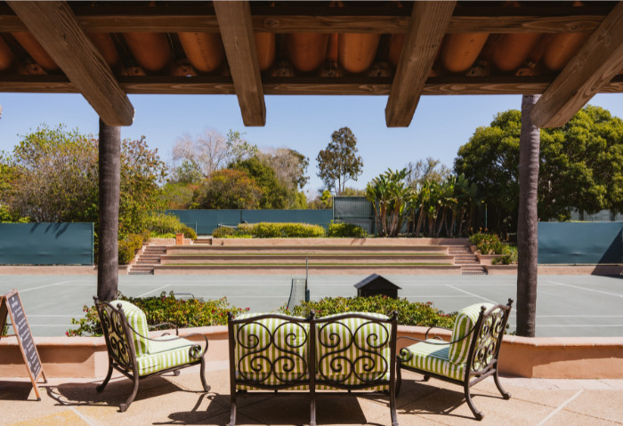 patio chairs at edge of tennis courts