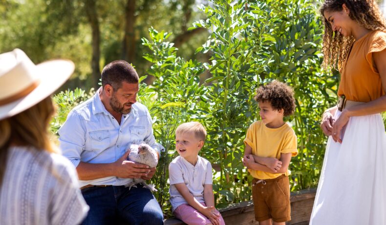 Man holding chicken with mothers and their sons