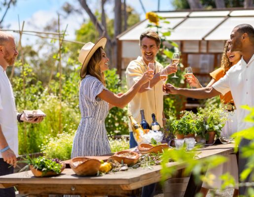 a group of people dining outside and toasting with champagne