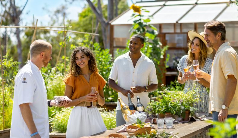 Two Couples and a chef enjoying wine in the Culinary Garden
