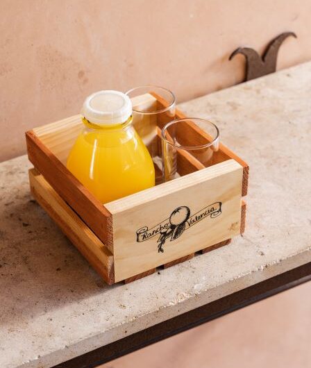 a bottle of orange juice in a small wooden crate