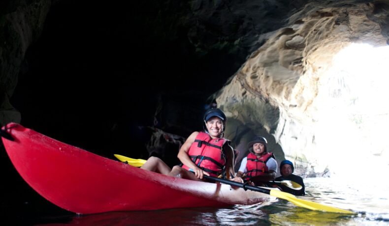 Mother and son kayaking through a cave