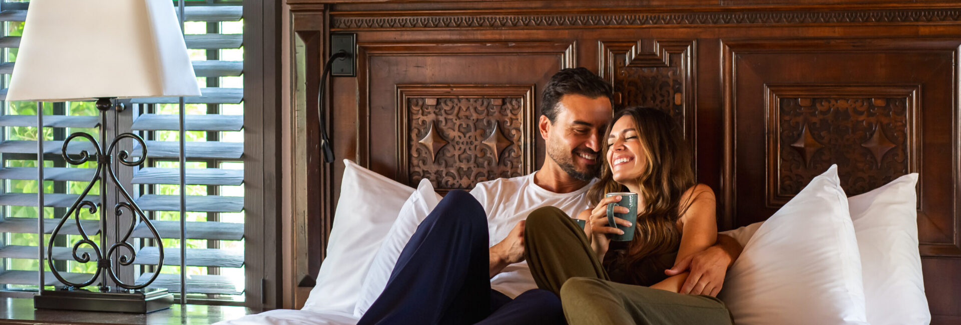 Couple snuggling on bed in casita