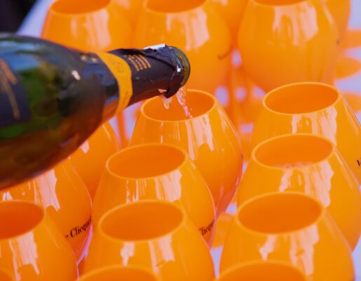 Orange champagne glasses with a bottle of Veuve