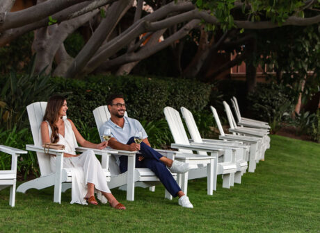 couple sitting outside on lawn on adirondack chairs