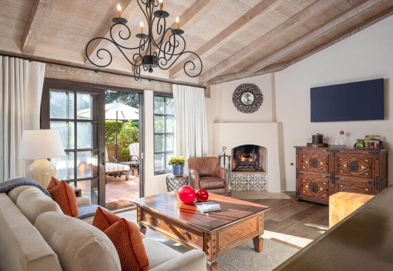 Eucalyptus ADA Two Queen Suite living area with corner fireplace and open patio door