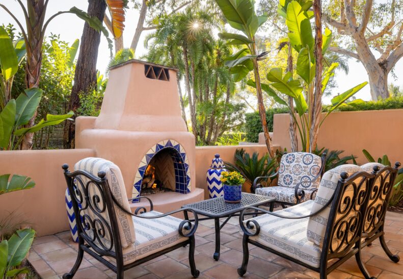 Palm Suite Patio with outdoor fireplace with table and chairs