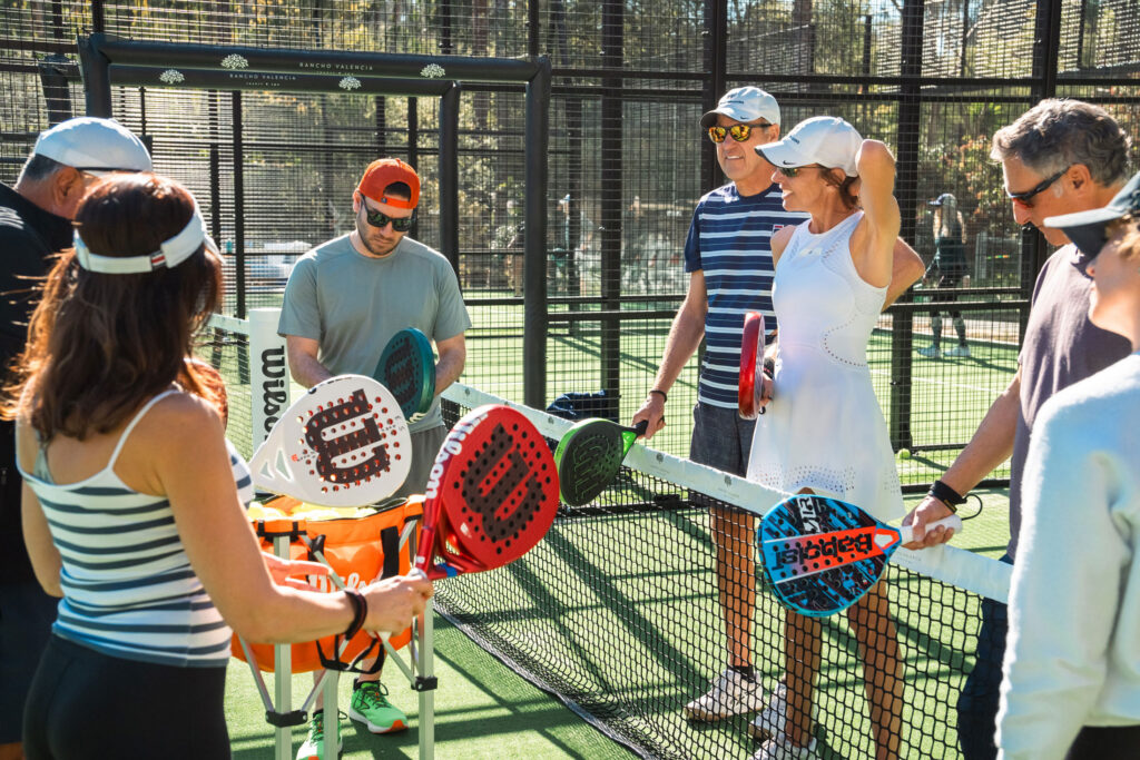 Group gathered at net with paddles.